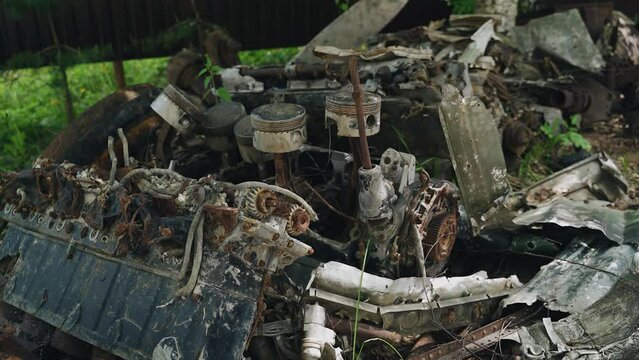 A rusty old large aircraft engine is lying in a landfill. Engine from a motor aircraft
