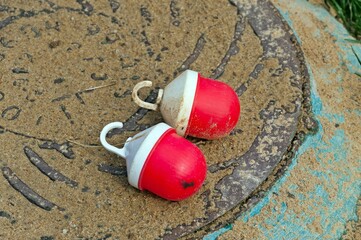 Two red construction lanterns are lying on the manhole cover