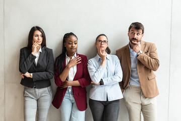 Group of young successful business people standing in the office building. Freelancer experts and colleagues thinking about project solutions. 