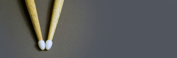 old drum sticks with plastic tips on gray background. Banner for insertion into site. Place for text cope space. Horizontal image