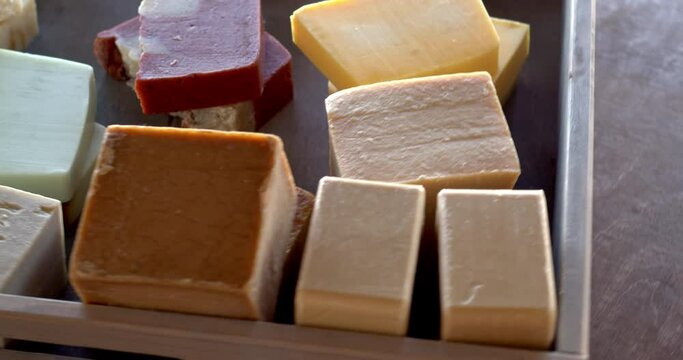 Different colorful and natural soaps in wooden box. Bio cosmetics, table spin.