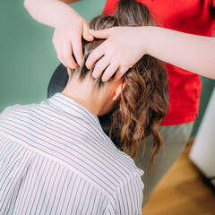 Naklejka premium Chair Massage in the Office. Female sitting in her office on a portable massage chair. Therapist massaging her neck for stress relief