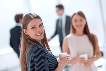 young businesswoman with a glass of coffee standing in the office