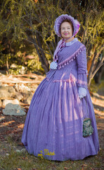 Woman in victorian dress walking in the park. Vintage fashion.