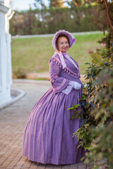 Fototapeta premium Woman in victorian dress walking in the park. Vintage fashion.