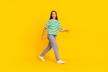 Fototapeta na wymiar Full size profile portrait of adorable satisfied person walking toothy smile isolated on yellow color background