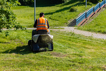   man on a lawn mower mows the grass