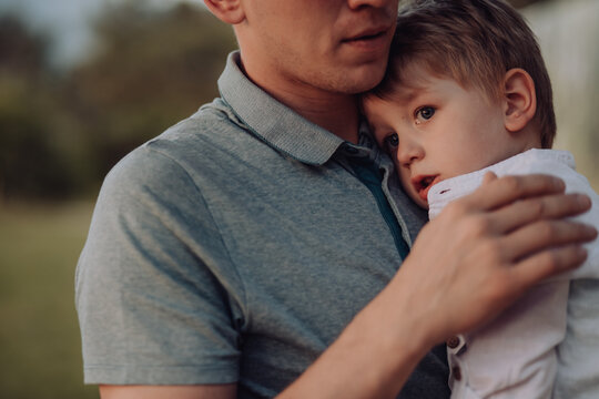 dad soothes a child, his son on a summer day outdoor. little boy crying in his father's arms. Fatherhood, parenting, care, father's day. Friendly family concept