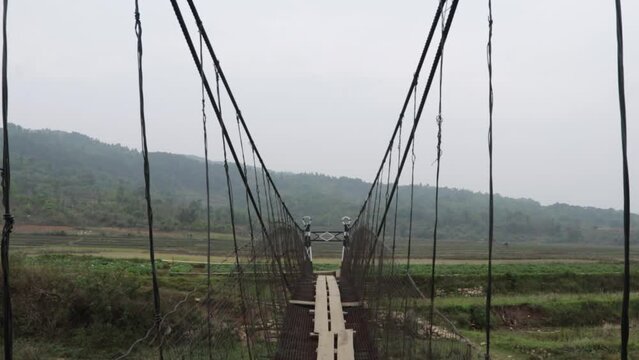 isolated old rusty iron suspension bridge with misty flat sky background at morning