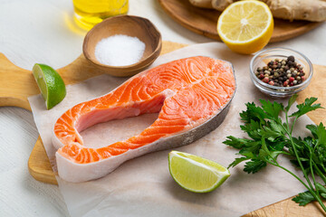 Close up of  salmon fish steak and spice, herbs oils on chopping board cooking food