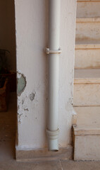 Peeling outdoor wall.  Vertical. The paint is peeling off. Paint chips from the wall. 