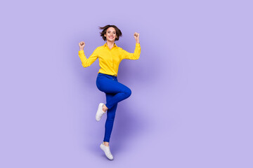 Fototapeta na wymiar Full body photo of hooray young brunette lady jump yell wear shirt trousers sneakers isolated on purple background