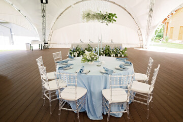 Floral table decoration for holidays and weddings. A set table for a celebration, event, party or wedding in an outdoor restaurant. Soft selective focus.