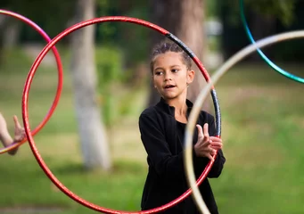 Fotobehang Girl doing exercise with hoop on rhythmic gymnastics training outdoors in summer in sports camp © Olena Shvets