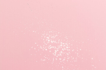 Sparkling silver glitter on pink background. Holiday blurred lights