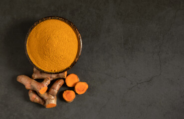 Flat lay (top view) of Turmeric powder and fresh turmeric (curcumin) on a black background, spices, copy space