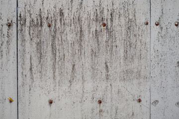 Fence made of asbestos cement sheet. The texture of an old fence with rusty rivets. Grunge background