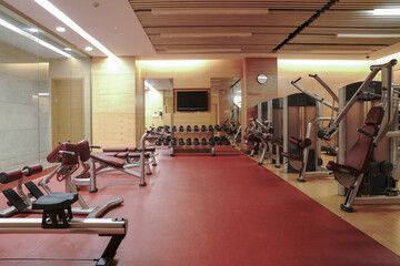 Modern light gym. Sports equipment in gym. Barbells of different weight on rack.	
