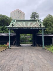 Obraz premium Beautiful entrance gate rooftop of Yushima shrine, a historic landmark built in the 17th century, once flourished as educational institute. shot taken year 2022 June 14th, rainy cloudy day 