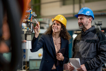 Female engineering manager and mechanic worker doing routine check up in industrial factory