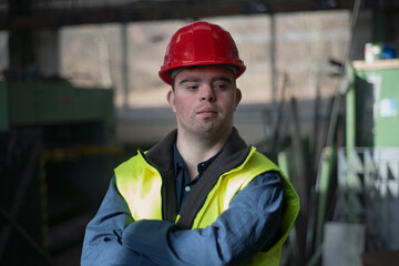 Young man with Down syndrome working in industrial factory, social integration concept.