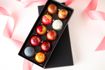 Open gift box with assortment of homemade chocolate bonbons. Modern hand painted chocolate candy....