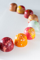 Modern hand painted with different colors  chocolate candy placed in a row. Product advertising...