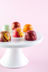 Sweet color chocolate bonbons on  a cake stand. Modern hand painted chocolate candy. Product concept for chocolatier