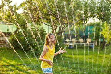 Happy kid girl playing with garden sprinkler run and jump, summer - obrazy, fototapety, plakaty