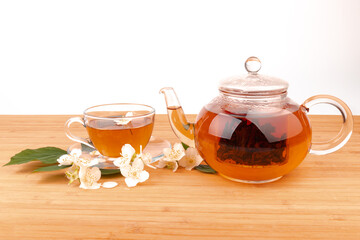 Composition with cup of jasmine tea and flowers on light background