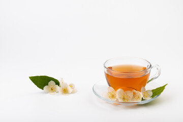 Composition with cup of jasmine tea and flowers on light background