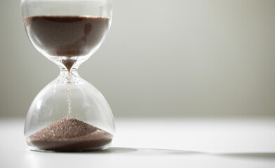 hourglass (sand clock) on the white table, Hourglass as time passing concept for business deadline, Life-time passing concept, elapsed time concept, with copy space
