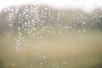 Naklejka na ściany i meble Natural pattern of rain drops on window glass surface.