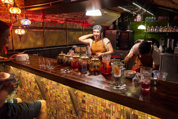 Male and female bartenders are making cocktails