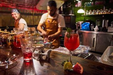 Male and female bartenders are making cocktails