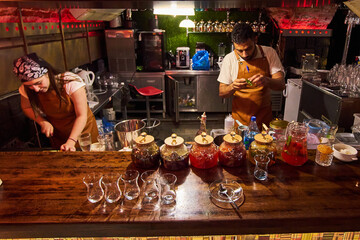 Male and female bartenders are making cocktails