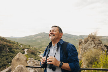 Happy senior man looking at the view from a hilltop - Powered by Adobe