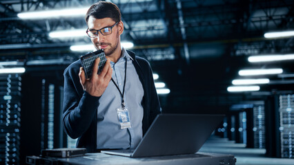 Successful Data Center IT Specialist Using Laptop Computer. Server Farm Cloud Computing Facility...