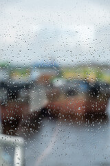 View through wet glass of the pier and ships