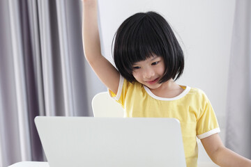 little asian girl student study online using laptop computer at home