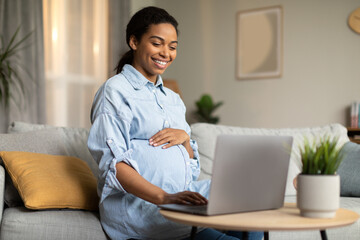Cheerful Pregnant Black Lady Using Laptop Working Online At Home