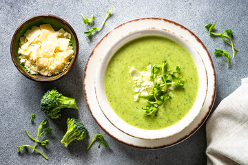 Broccoli cream soup with parmesan. Healthy green soup, vegan dish. Top view at stone table.