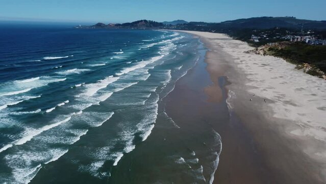 Clockwise drone shot of waves crashing on Nye Beach, a beach in the small town of Newport on the Oregon coast. This 4K cinematic Pacific Northwest scene was filmed using a DJI Mini 2 drone.