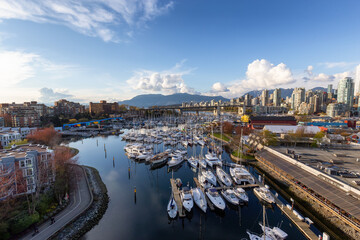 Obraz premium View of Vancouver City in False Creek, BC, Canada. Sunny Cloudy Day. Modern Cityscape, Granville Island, residential homes, marina and buildings.