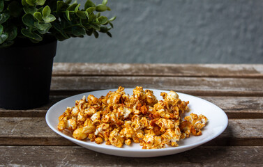 Crunchy and yummy sweet caramel popcorn in a plate. Caramel flavored popcorn