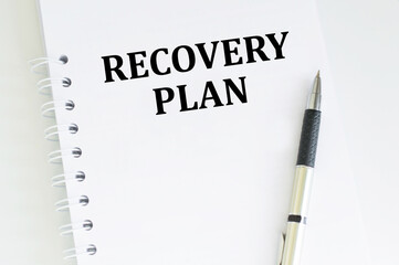 Text RECOVERY PLAN on a notepad on a table next to a pen, a business concept