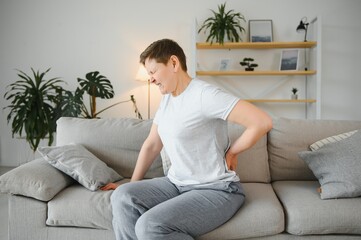 woman stand up from chair touch back suffer from spinal spasm or strain, sick mature female...