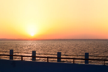 Obraz premium Sunset Over The Tropical Sea or Sunset over the arabian Sea. Bright Orange Sun Setting on Beautiful Blue Water. located in Diu district of Union Territory Daman and Diu Gujarat India.