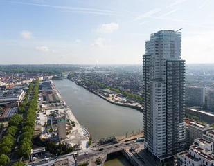 Foto op Plexiglas anti-reflex Brussels, Belgium - May 12, 2022: Urban landscape of the city of Brussels, skyscraper apartment building with the river Senne crossing Brussels and in the background the industries of the port © Eric Isselée
