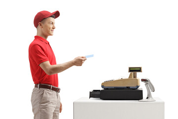 Young male worker at a cash register holding a credit card